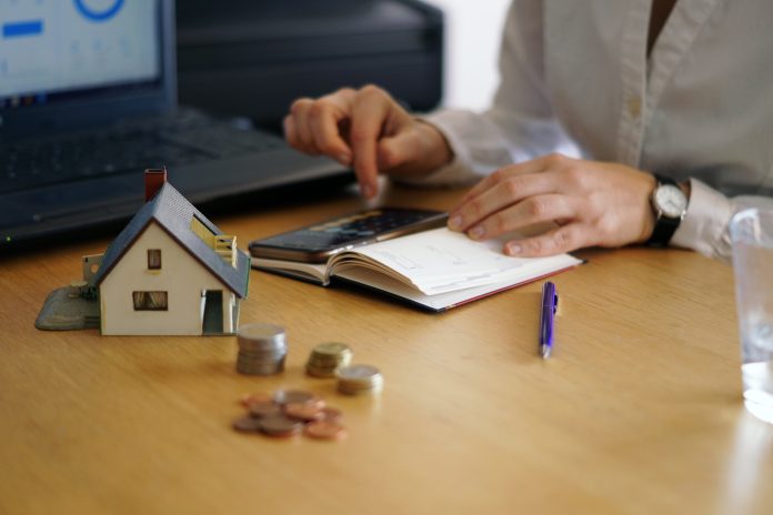 primer plano de persona pensando si comprar casa, haciendo cuentas de crédifo hipotecario en comfamiliar.