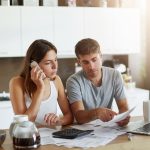 joven-empresario-senalando-dedo-al-documento-tratando-expandir-algo-su-esposa-que-hablando-telefono-inteligente-pareja-revisando-sus-cuentas-bancarias-calculando-cifras-anuales (1) (1)